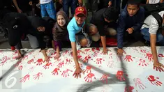 Pengunjung CFD membubuhkan cat telapak tangan saat gerakan Deklarasi Anti Korupsi di Bundaran HI, Jakarta, Minggu (27/11). Aksi ini dilakukan jelang diperinngatinya Hari Anti Korupsi Sedunia  9 Desember. (Liputan6.com/Johan Tallo) 