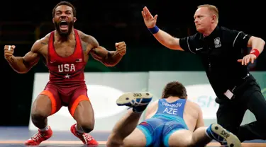 Burroughs Jordan dari AS (kiri) merayakan kemenangan usai mengalahkan Gasjimurad Omarov dari Azerbaijan dalam pertandingan gulat 74 kilogram di Freestyle Wrestling World Cup di Iowa City, Iowa (8/4). (AP Photo/Charlie Neibergall)