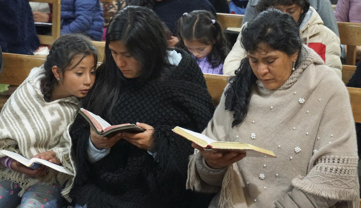 Calon ibu negara Peru, Lilia Paredes (48) membaca Alkitab sambil duduk di sebelah adiknya Yenifer dan sang putri Alondra (9) selama kebaktian gereja di mana para tetangga diundang untuk mengucapkan selamat tinggal sebelum keberangkatan keluarga ke Lima, di Chugur, 22 Juli 2021. (AP/Franklin Briceno)