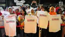 Pendukung Jokowi-Ma'ruf Amin mengangkat kaus pada acara Doa Bersama Lintas Agama dan Festival Seni Budaya di Jakarta, Jumat (12/4). Acara yang digelar Gerakan Alumni UI dan IKJ mengusung tema "SATUkan Doa menuju Kemenangan". (Liputan6.com/Angga Yuniar)