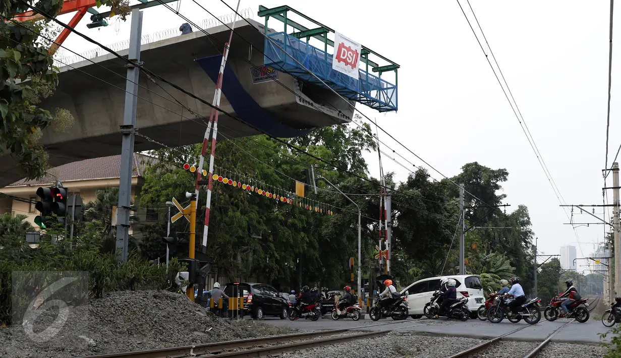 Sejumlah kendaraan melintasi perlintasan kereta api di kawasan Patal Senayan, Jakarta, Selasa (6/10/2015). Pembangunan flyover Permata Hijau di atas perlintasan kereta api di kawasan tersebut sudah mencapai 70 persen. (Liputan6.com/Yoppy Renato)