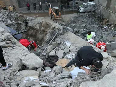 Tim penyelamat memeriksa reruntuhan bangunan setelah serangan udara Israel di desa Shebaa, Lebanon Selatan, pada 27 September 2024. (Rabih DAHER/AFP)