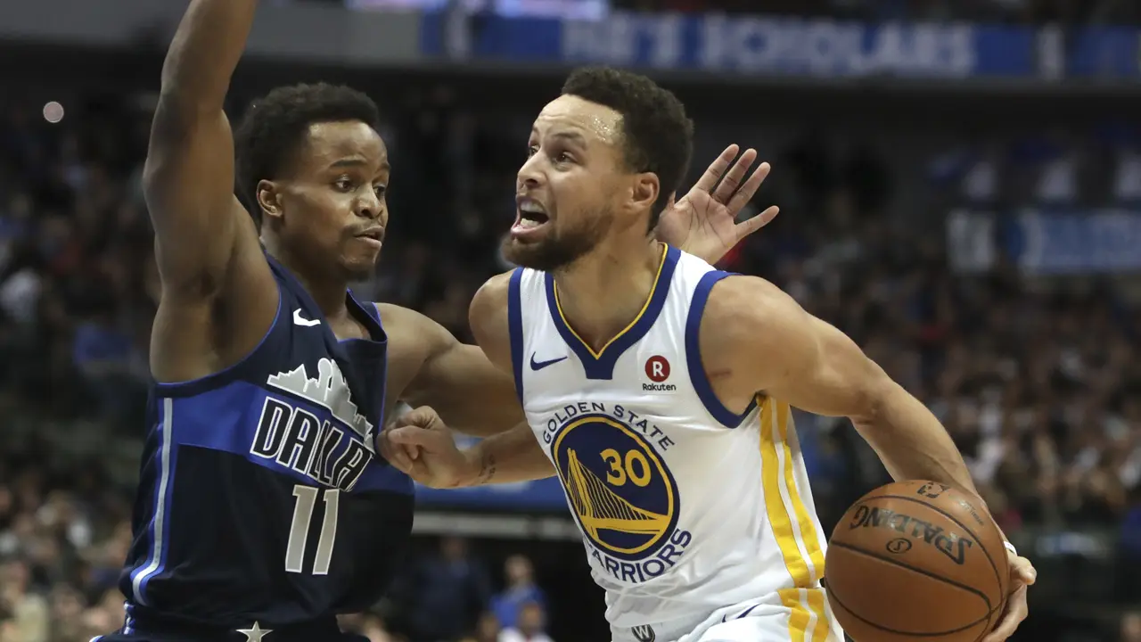 Aksi Stephen Curry (putih) saat melawan Mavericks