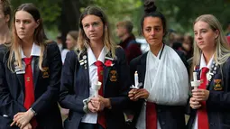 Para pelajar menggelar aksi lilin saat mengenang korban penembakan di luar Masjid Al Noor, Christchurch, Selandia Baru, Senin (18/3). Penembakan tersebut merupakan serangan terburuk dalam sejarah Selandia Baru modern. (AP Photo/Vincent Yu)