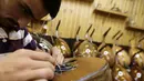 Pekerja memasang senar melengkapi proses pembuatan alat musik Oud di sebuah rumah produksi di Damaskus, Suriah (17/7). Biasanya Oud ini dimainkan sambil diiringi gendang. (AFP Photo/Louai Beshara)