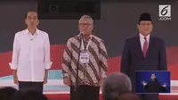 Ketua KPU Arief Budiman (tengah) bersama capres nomor urut 01 Joko Widodo (kiri) dan capres nomor urut 02 Prabowo Subianto (kanan) menyanyikan lagu Indonesia Raya saat debat kedua capres Pilpres 2019 di Hotel Sultan, Jakarta, Minggu (17/2). (Liputan6.com)