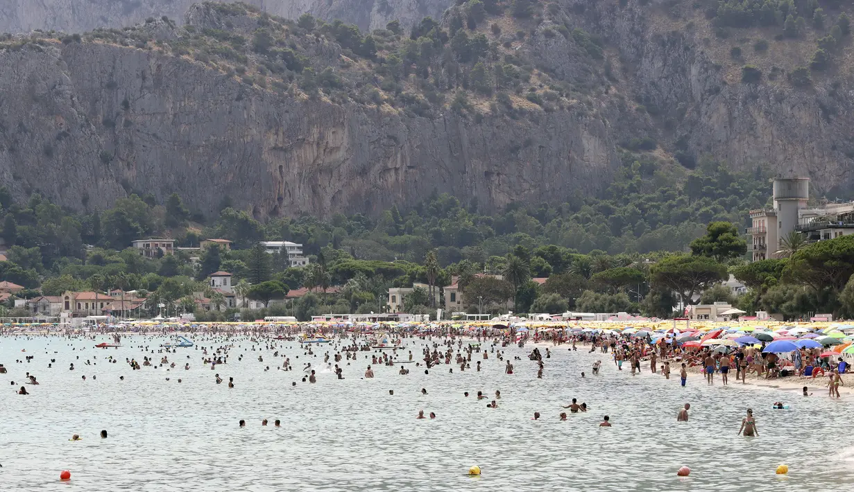 Orang-orang menyegarkan diri di laut di Palermo, Italia, Rabu (11/8/2021). Gelombang panas yang berkelanjutan akan berlangsung hingga akhir pekan dengan suhu diperkirakan mencapai lebih dari 40 derajat Celcius di banyak bagian Italia. (Alberto Lo Bianco/LaPresse melalui AP)