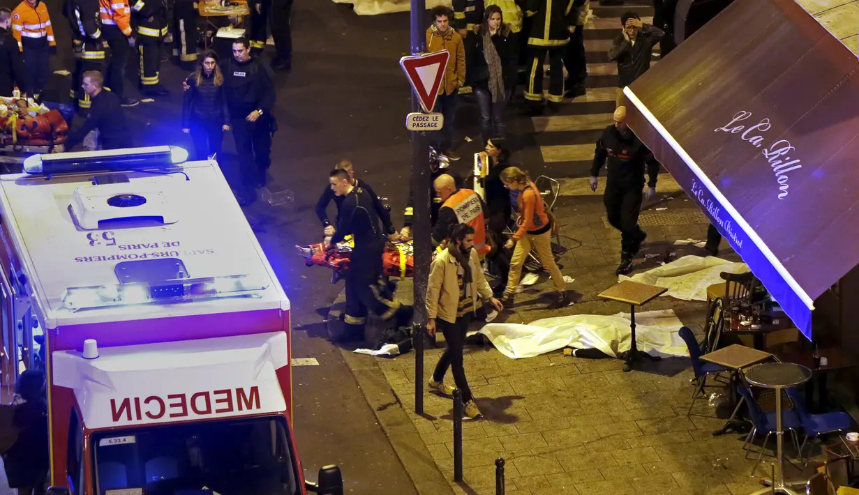 Petugas berusaha menyelamatkan korban dari aksi penembakan dan bom bunuh diri yang dilakukan teroris di Paris, Perancis, Jumat (13/11/2015). Dikabarkan ada 140 orang tewas dalam aksi teroris tersebut. (Reuters)