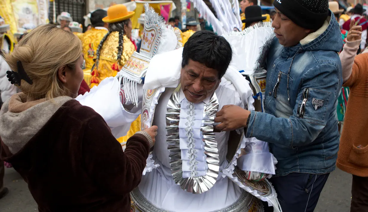 Seorang peserta bersiap mengenakan kostum untuk mengikuti parade tahunan ""El Senor del Gran Poder" di La Paz, Bolivia (10/6). Parade ini merupakan bentuk penghormatan mereka kepada sang dewa. (AP Photo / Juan Karita)