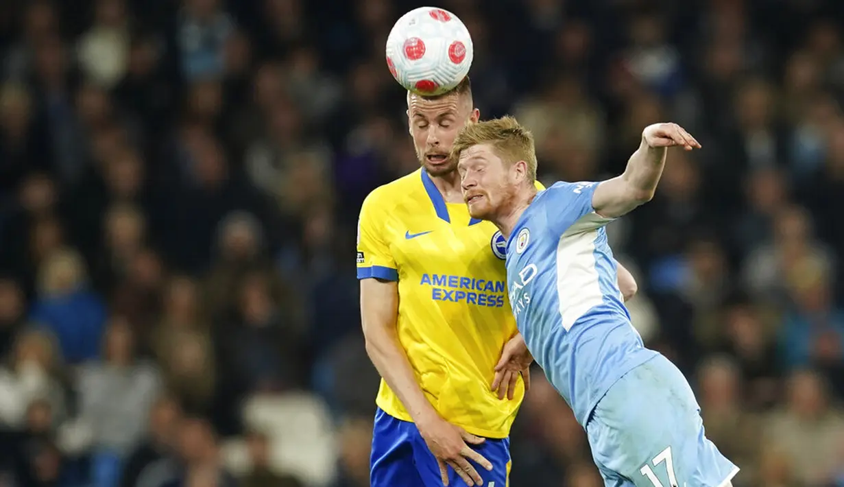 Pemain Brighton and Hove Albion Adam Webster (kiri) menyundul bola melewati pemain Manchester City Kevin De Bruyne pada pertandingan sepak bola Liga Inggris di Etihad Stadium, Manchester, Inggris, 20 April 2022. Manchester City menang 3-0. (AP Photo/Dave Thompson)