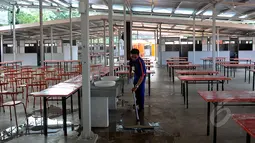 Seorang petugas tampak membersihkan area kios dari genangan air, Jakarta, Kamis (9/4/2015). Pemda DKI Jakarta telah menyeleksi 339 PKL yang akan menempati kios tersebut. (Liputan6.com/Johan Tallo)