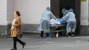 Petugas medis membawa ranjang pasien dengan jenazah keluar dari departemen infeksi COVID-19 di sebuah klinik kota di Kyiv, Kamis (21/10/2021). Infeksi dan kematian virus corona di Ukraina telah melonjak ke level tertinggi sejak pandemi di tengah laju vaksinasi yang lamban. (AP Photo/Efrem Lukatsky)