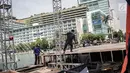 Pekerja menyelesaikan pembuatan panggung HUT ke-492 DKI di area Bundaran HI, Jakarta, Kamis (20/6/2019). Sejumlah artis Ibu Kota akan menghibur dalam peringatan HUT ke-492 DKI Jakarta. (Liputan6.com/Faizal Fanani)