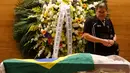 Seorang pelayat yang memberi penghormatan didekat jenazah mantan pemain sepak bola Brasil, Carlos Alberto yang sedang disemayamkan di di Konfederasi Sepakbola Brasil (CBF) di Rio de Janeiro, Brasil (25/10). (Reuters/ Ricardo Moraes)