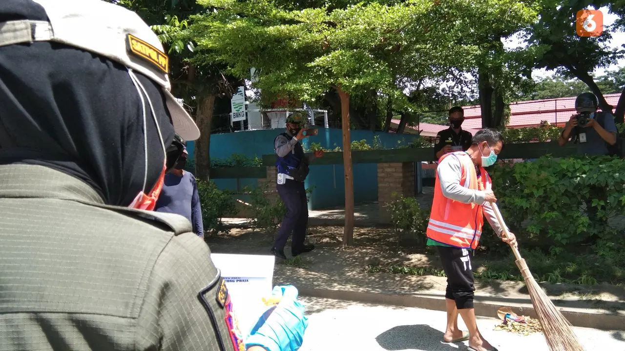 personel Pol PP Palu mengawasi seorang pelanggar protokol kesehatan