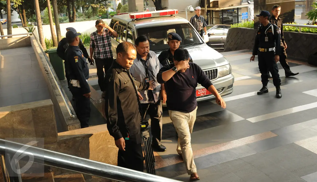 Dua tersangka hasil OTT KPK menutup wajahnya saat turun dari mobil dan digiring masuk ke gedung KPK Jakarta, Sabtu (20/6/2015). KPK mengamankan empat orang hasil OTT yang berlangsung pada Jumat (19/6) malam di Palembang. (Liputan6.com/Helmi Fithriansyah)