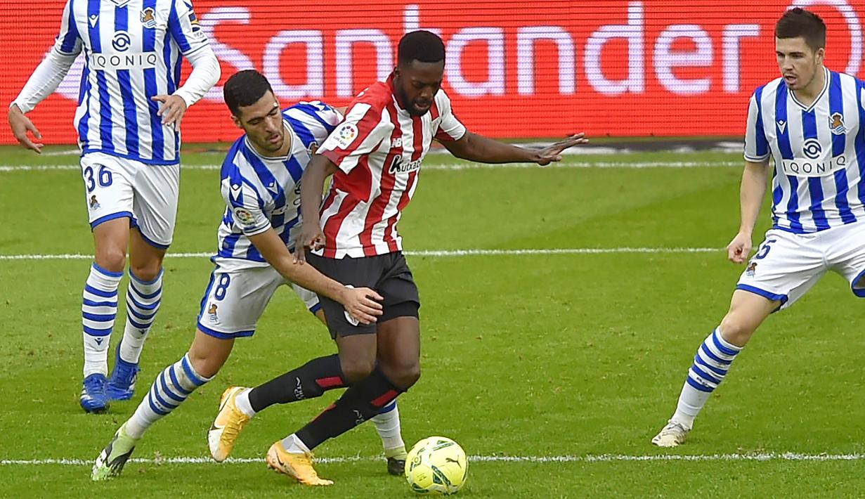 Pemain Athletic Bilbao, Inaki Williams, berusaha melewati pemain Real Sociedad, Mikel Oyarzabal, pada laga liga Spanyol di Stadion San Mames, Kamis (31/12/2020). Real Sociedad menang dengan skor 1-0. (AFP/Ander Gillenea)
