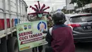 Polisi memakai helm bertema virus corona COVID-19 saat melakukan kampanye dan penyemprotan disinfektan kepada pengendara di Mojokerto, Jawa Timur, Jumat (3/4/2020). Aksi ini dilakukan sebagai tindakan pencegahan penyebaran virus corona COVID-19. (JUNI KRISWANTO/AFP)