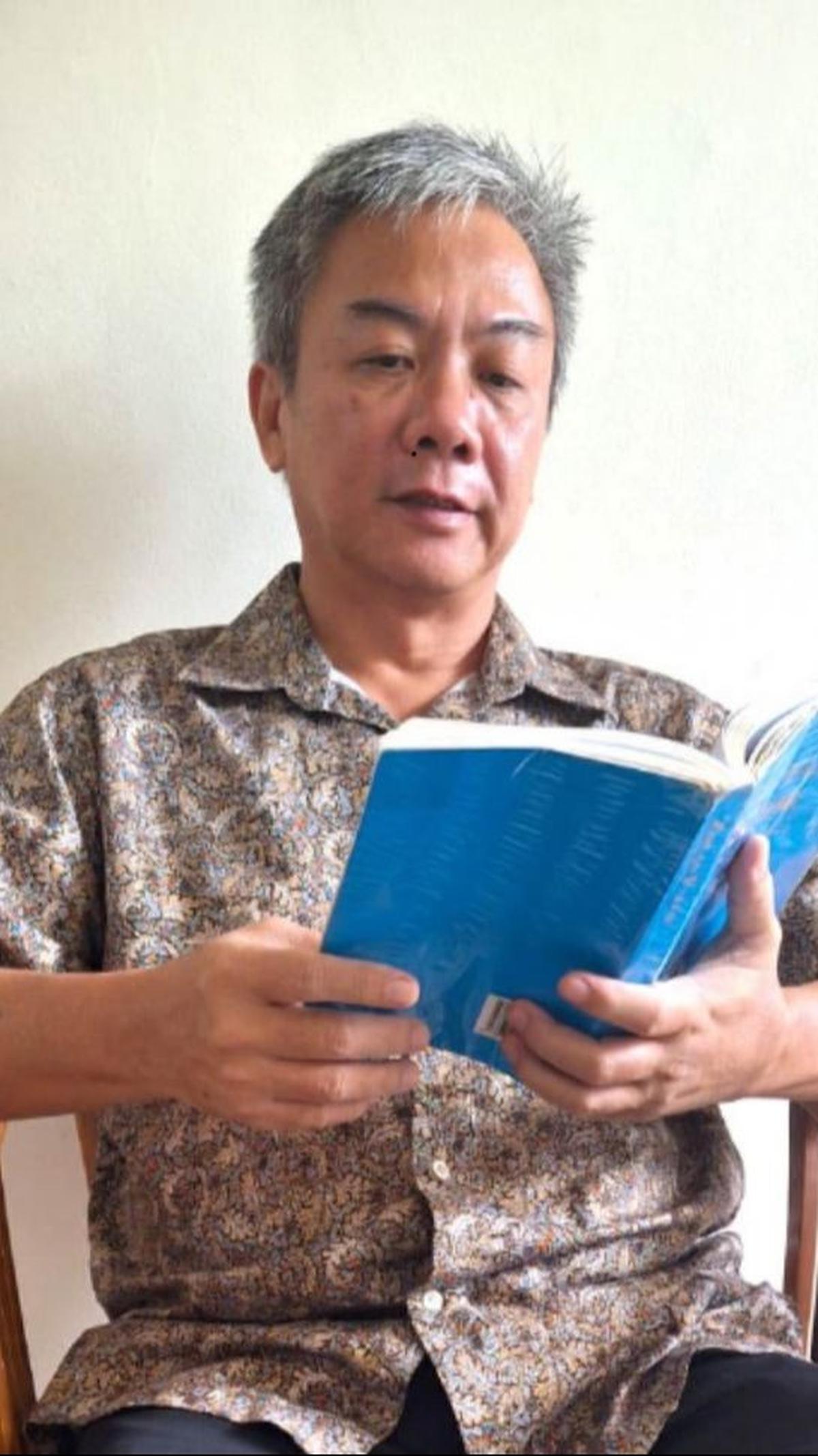 Ronald sedang Membaca buku Zhuan Falun