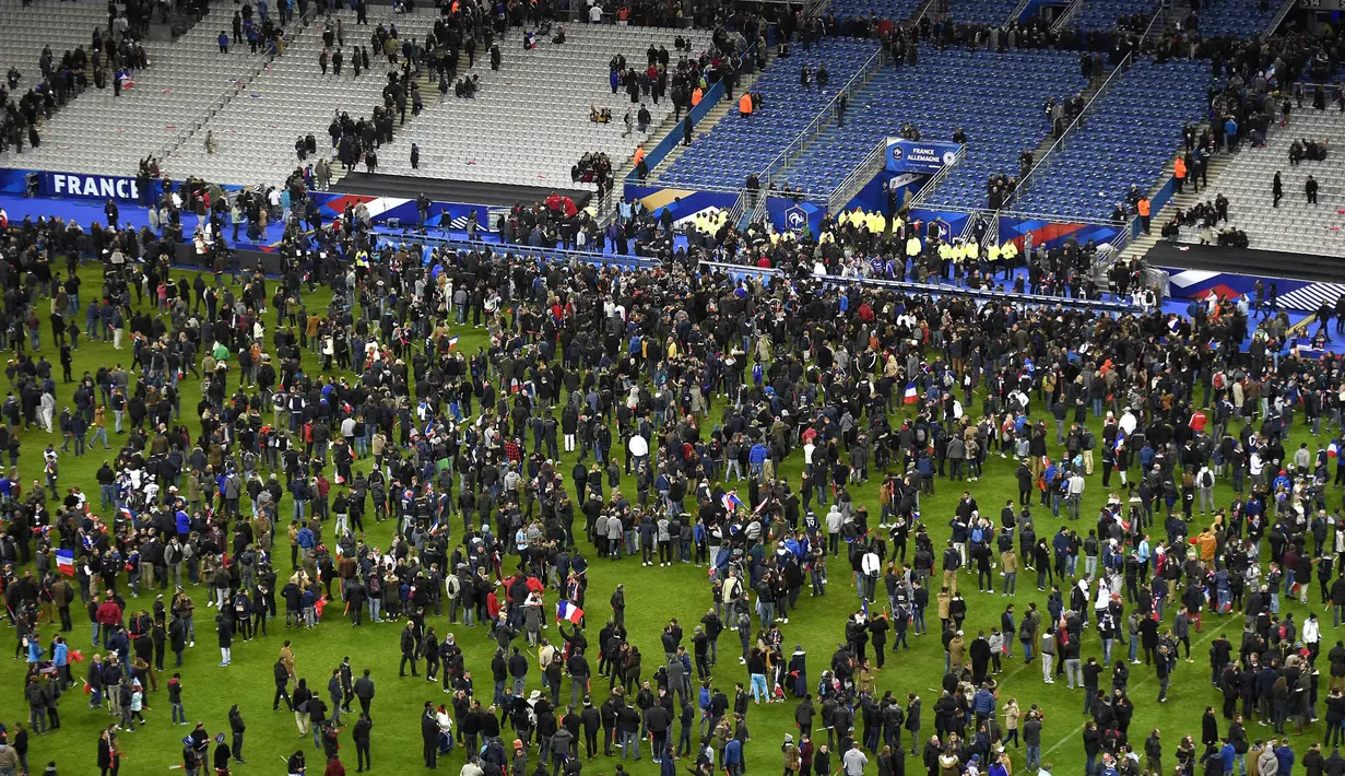 Para penonton ditahan di dalam stadion untuk menghindari serangan bom dan juga kelompok bersenjata di Stadion Stade de France, Prancis, Sabtu (13/11/2015). (AFP Photo/Franck Fife)