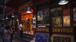 Calon penonton antre membeli tiket di bioskop terbuka Zephyros, Athena, Yunani, 1 Agustus 2020. Pandemi COVID-19 memaksa bioskop terbuka dipersingkat sehingga menyebabkan penurunan jumlah penonton. (ANGELOS TZORTZINIS/AFP)