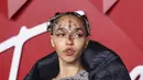 FKA Twigs berpose untuk fotografer setibanya di British Fashion Awards di London, Senin, 5 Desember 2022. Gaunnya menampilkan panel garis tipis dari bahan berjumbai yang menambahkan beberapa dimensi padanya.Dia menyelipkan kakinya ke dalam sepasang tumit platform hitam dan abu-abu yang menambahkan beberapa inci ke tubuhnya. (Photo by Vianney Le Caer/Invision/AP)