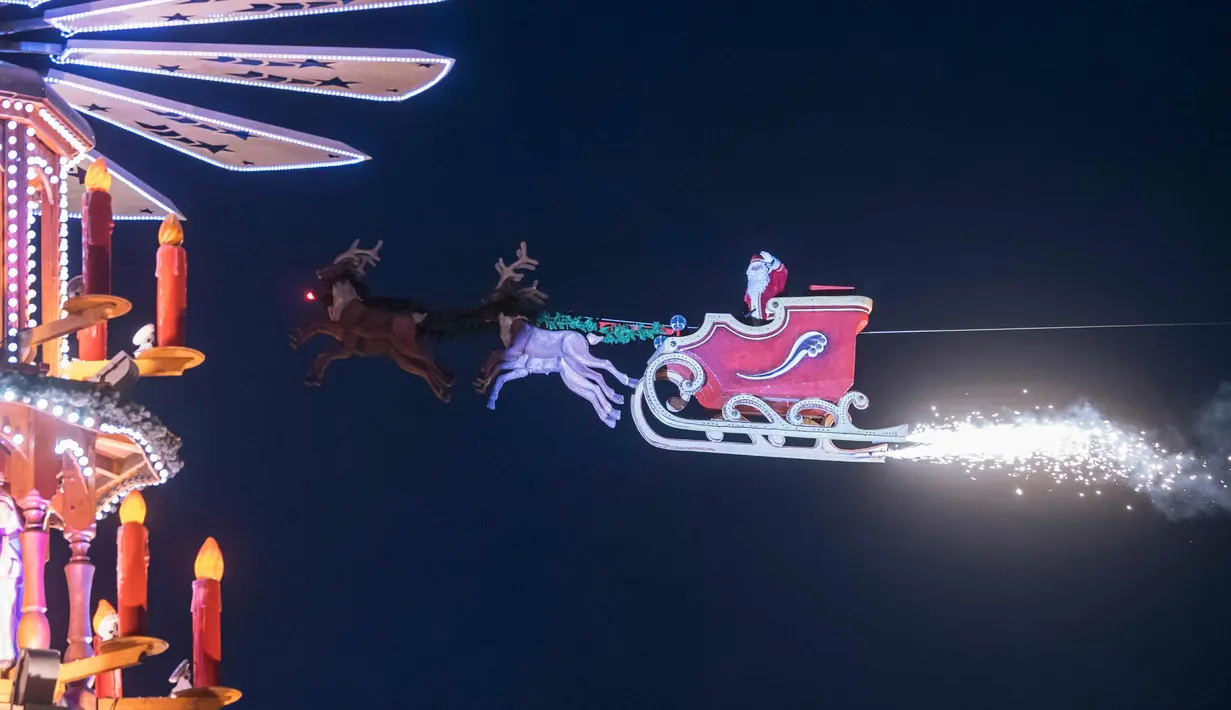 Falko Traber memakai kostum Santa Claus berada di kereta rusa di pasar Natal di Karlsruhe, Jerman selatan, (5/12).  (AFP Photo/dpa/Uli Deck /Germany Out)