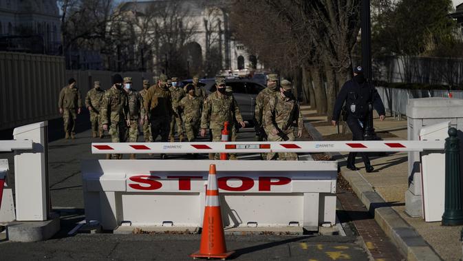 Pasukan Garda Nasional berjalan di halaman Capitol Hill sehari setelah massa pendukung Donald Trump menerobos masuk ke Gedung Capitol, Washington, DC. Kamis (7/1/2021). Penyerbuan dilakukan saat para anggota Kongres hendak mengesahkan kemenangan Joe Biden. (AP Photo/Evan Vucci)