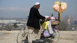 Seorang pedagang membuat gulali selama perayaan Nowruz, Tahun Baru Persia, di Kabul, Afghanistan, (21/3). Nowruz dirayakan pada hari pertama musim semi di negara-negara termasuk Afghanistan, Tajikistan, dan Iran. (AP Photo/Rahmat Gul)
