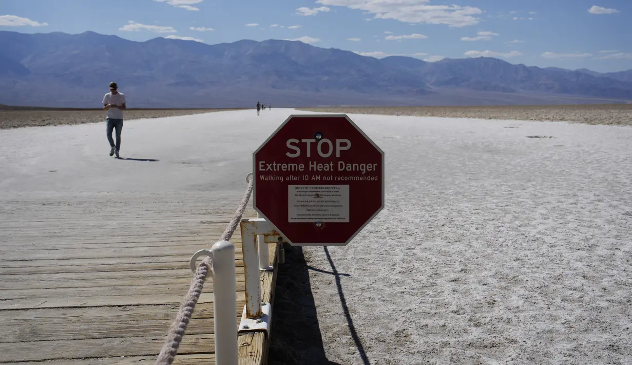 Sebuah tanda peringatan bahaya panas ekstrem di Badwater Basin, di Taman Nasional Death Valley, Taman Nasional Death Valley, California, Kamis (1/9/2022). Tempat wisata populer di California ini merupakan  salah satu tempat terpanas dan terkering yang ada di dunia.  (AP Photo/John Locher)