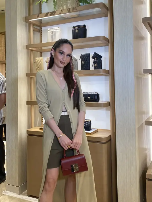 Cinta Laura tampil dengan long cardigan warna hijau army yang serasi mini skirtnya.  [Anisha Saktian]