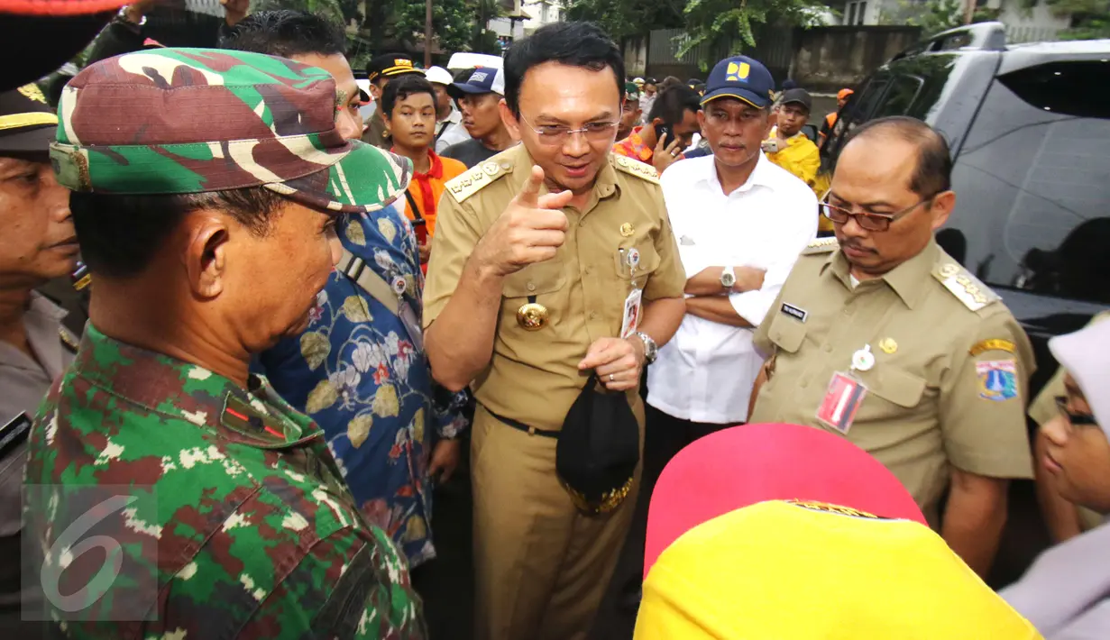 Ahok didampingi jajarannya saat blusukan di Bukit Duri, Jakarta, Senin (20/2). Ahok mengatakan untuk wilayah Bukit Duri, tidak ada cara lain untuk menanggulangi banjir selain normalisasi. (Liputan6.com/Helmi Afandi)