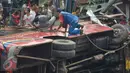 Petugas berusaha mengevakuasi bangkai bus Trans Semarang yang menabrak pangkalan ojek di Jalan Sultan Agung, Semarang, Minggu (17/7). Akibat kejadian tersebut, sedikitnya 23 orang mengalami luka-luka. (Liputan6.com/Gholib)