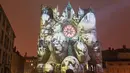 Karya instalasi lampu seniman Yann Nguema, menghiasi bangunan Gereja Katedral Saint-Jean saat persiapan Festival of Lights (Fete des Lumieres) di pusat Kota Lyon, Prancis (7/12). (Reuters/Emmanuel Foudrot)