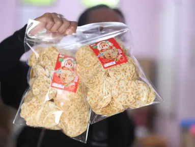 Pekerja menunjukkan salah satu hasil produksi pembuatan keripik tempe di rumah usaha Keripik Tempe Mama Tina, Kebayoran Baru, Jakarta Selatan, Kamis (7/5/2026). Keripik Tempe Mama Tina merupakan usaha rumahan memproduksi keripik tempe dengan beragam varian rasa seperti original bawang putih, balado, barbeque, hingga sapi panggang. (merdeka.com/Arie Basuki)