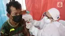 Vaksinator menyuntikkan vaksin Sinovac kepada warga di area TPST Bantargebang, Kota Bekasi, Jumat (29/10/2021). 300 dosis vaksin perhari disiapkan untuk vaksinasi pertama maupun kedua bagi masyarakat dan komunitas pemulung di sekitar TPST Bantargebang. (Liputan6.com/Helmi Fithriansyah)