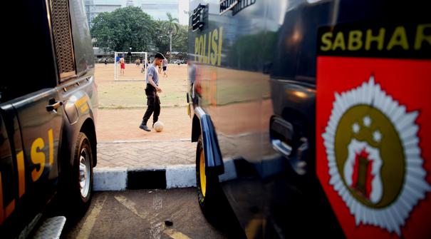 Polisi dari kesatuan Sabhara merenggangkan otot dengan bermain bola di Kawasan Polda Metro, Jakarta, Selasa (13/10/2015). Pihak Kepolisian dan TNI bersiap siaga menjelang laga Final Piala Presiden 2015. (Bola.com/Nicklas Hanoatubun).