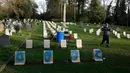 Pekerja bersiap membersihkan batu nisan kuburan Harefield di Hillingdon, Inggris, Rabu (23/11). Kuburan prajurit Australia & New Zealand yang tewas pada Perang Dunia I dicoret dengan graffiti kedua kalinya dalam 7 bulan terakhir. (REUTERS/Stefan Wermuth)