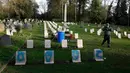 Pekerja bersiap membersihkan batu nisan kuburan Harefield di Hillingdon, Inggris, Rabu (23/11). Kuburan prajurit Australia & New Zealand yang tewas pada Perang Dunia I dicoret dengan graffiti kedua kalinya dalam 7 bulan terakhir. (REUTERS/Stefan Wermuth)