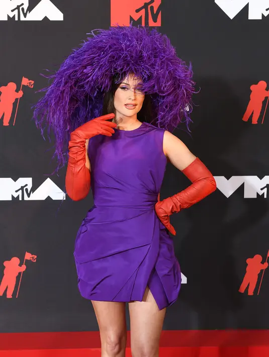 Kacey mengenakan mini dress warna ungu tua rancangan Valentino Haute Couture. Feathered headpiece dan red leather gloves sebagai aksesori pun membuat looknya makin stunning!(dok/TPGimages).