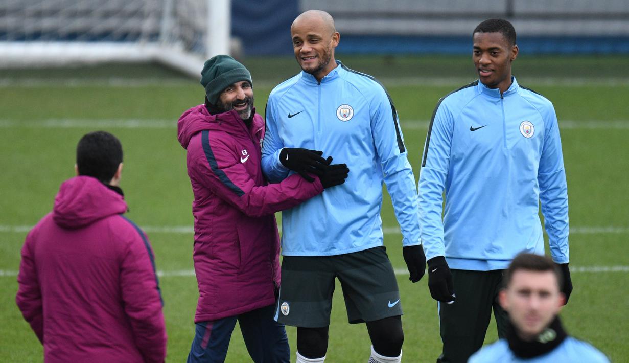 Bek Manchester City, Vincent Kompany, bercanda dengan staf pelatih saat sesi latihan jelang laga Liga Champions di Manchester, Selasa (6/3/2018). Manchester City akan berhadapan dengan FC Basel. (AFP/ Oli Scarff)
