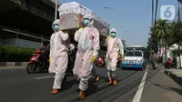 Petugas gabungan dari Kecamatan Cilandak dan Polsek Cilandak mengarak instalasi peti mati jenazah Covid-19 di kantor kecamatan Cilandak, Jakarta, Jumat (28/8/2020). Sosialisasi tersebut dilakukan untuk memberikan peringatan akan bahaya penularan virus Covid-19. (Liputan6.com/Herman Zakharia)