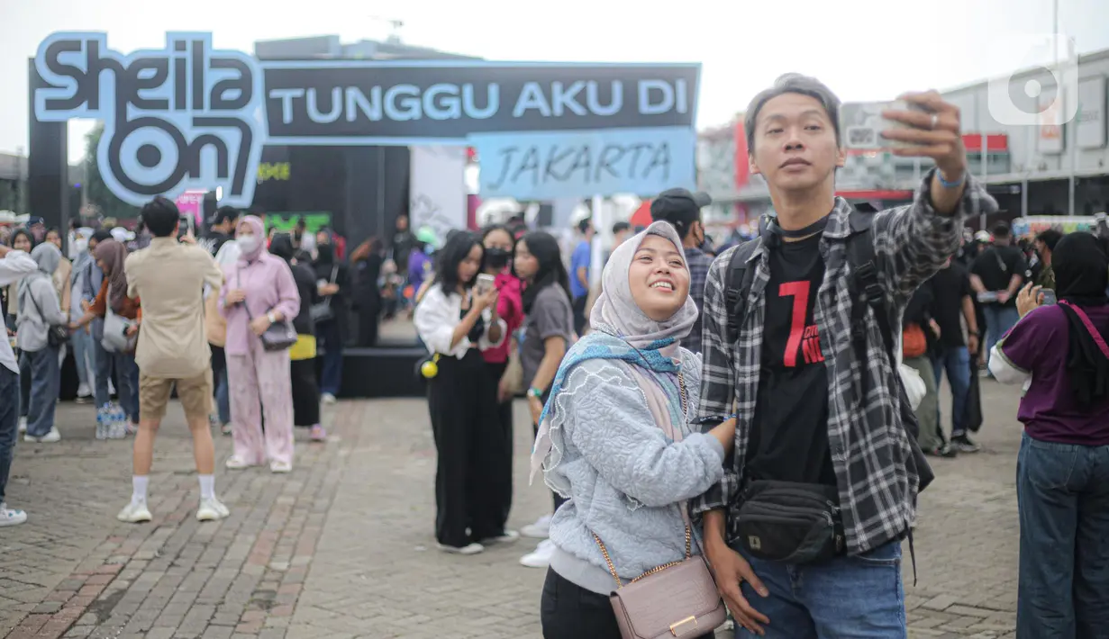 Penonton melakukan swafoto saat berlangsungnya konser Sheila On 7 yang bertajuk 'Tunggu Aku di Jakarta' di kawasan JIExpo Kemayoran, Jakarta Pusat, Sabtu, (28/1/2023). Jelang penampilan grup musik Sheila On 7 dalam konser bertajuk 'Tunggu Aku di Jakarta' penonton mulai memadati kawasan tersebut. (Liputan6.com/Faizal Fanani)