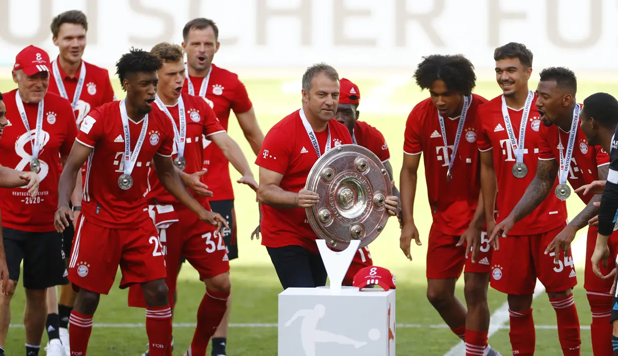 Pelatih kepala Bayern Munchen Hans-Dieter Flick mengangkat trofi juara Bundesliga usai mengalahkan  Wolfsburg di Wolfsburg, Jerman, 27 Juni 2020. (Photo by KAI PFAFFENBACH/POOL/AFP)