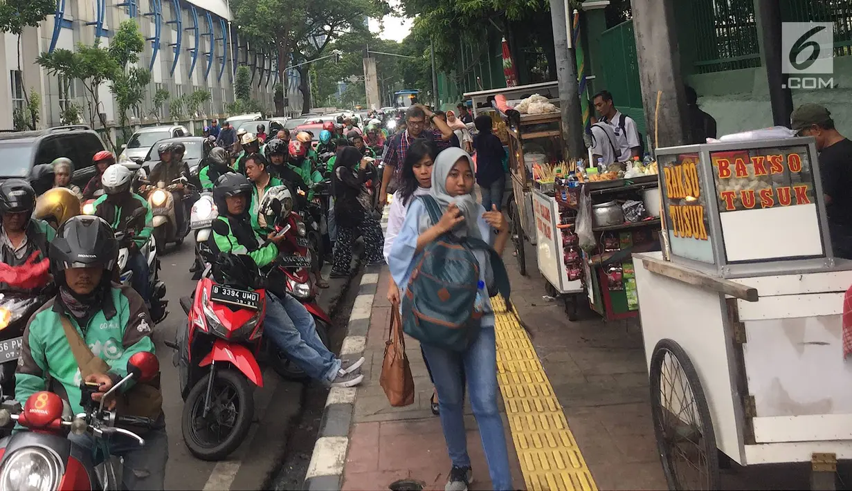 Pedagang kaki lima (PKL) dan ojek online memadati kawasan Stasiun Palmerah, Jakarta, Kamis (6/12). Kurangnya pengawasan petugas menyebabkan trotoar dan bahu jalan dipenuhi oleh PKL dan ojek online. (Liputan6.com/Immanuel Antonius)