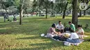 Warga menyantap makanan saat berkunjung ke Lapangan Banteng, Jakarta Pusat, Minggu (19/6/2022). Sejak kembali dibuka usai pandemi COVID-19 mereda, Lapangan Banteng kian ramai didatangi warga Jakarta dan menjadi salah satu lokasi wisata alternatif untuk menghabiskan waktu bersama keluarga serta sarana olahraga. (merdeka.com/Iqbal S. Nugroho)