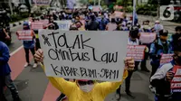 Massa yang tergabung dalam Front Perjuangan Rakyat (FPR) membawa poster saat berunjuk rasa di Jalan Gerbang Pemuda, Senayan, Jakarta, Jumat (14/8/2020). Dalam aksinya mereka menolak rencana pengesahan RUU Cipta Kerja atau omnibus law. (Liputan6.com/Faizal Fanani)