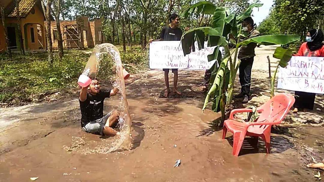 Sindir Pemerintah, Warga Ogan Ilir Mandi Air Comberan di Lubang Jalan