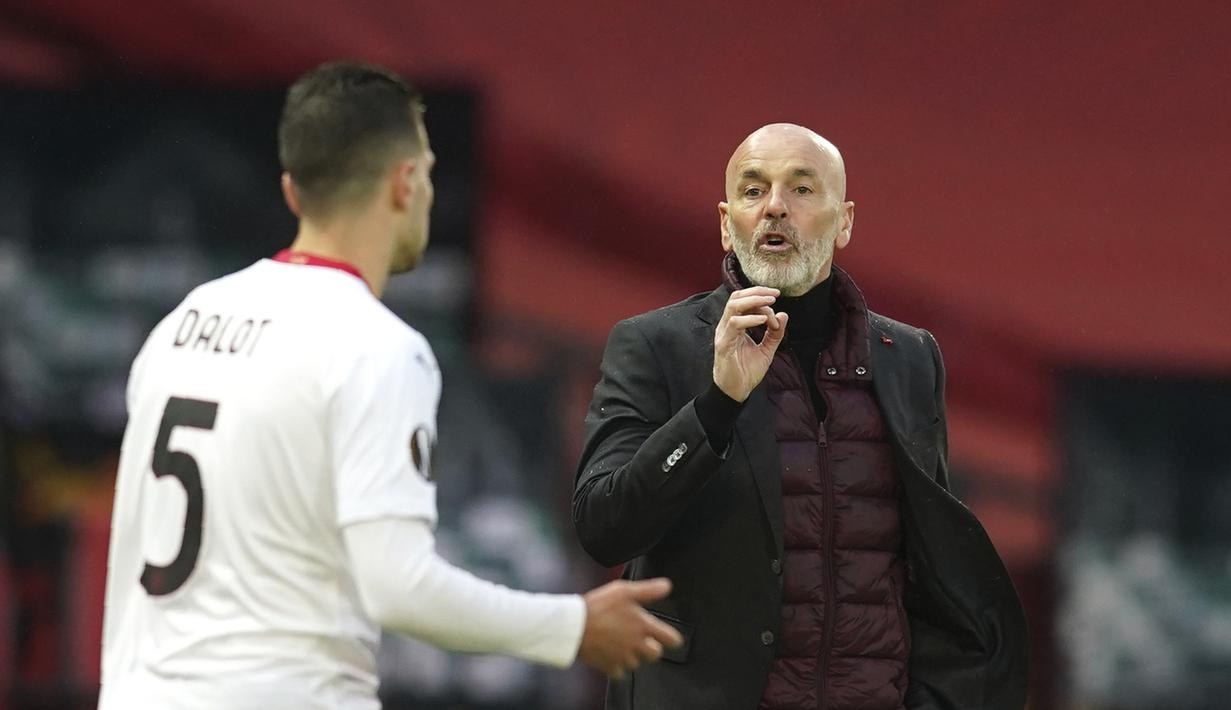 Pelatih AC Milan, Stefano Pioli menginstruksikan bek Diogo Dalot saat bertanding melawan Manchester United pada pertandingan leg pertama babak 16 besar Liga Europa di Old Trafford, Inggris, Jumat (12/3/2021). Hasil ini penting bagi AC Milan dalam format duel dua leg. (AP Photo/Dave Thompson)