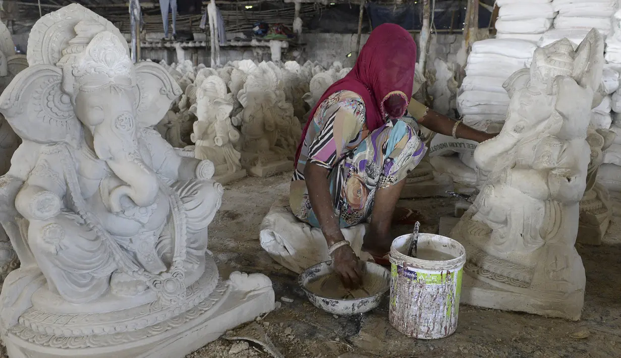 Perajin menyelesaikan pembuatan patung Dewa Ganesha di sebuah bengkel di pinggiran Hyderabad, India, Senin (29/6/2020). Patung Dewa Ganesha banyak ditemukan di berbagai penjuru India termasuk Nepal, Tibet, dan Asia Tenggara. (NOAH SEELAM/AFP)